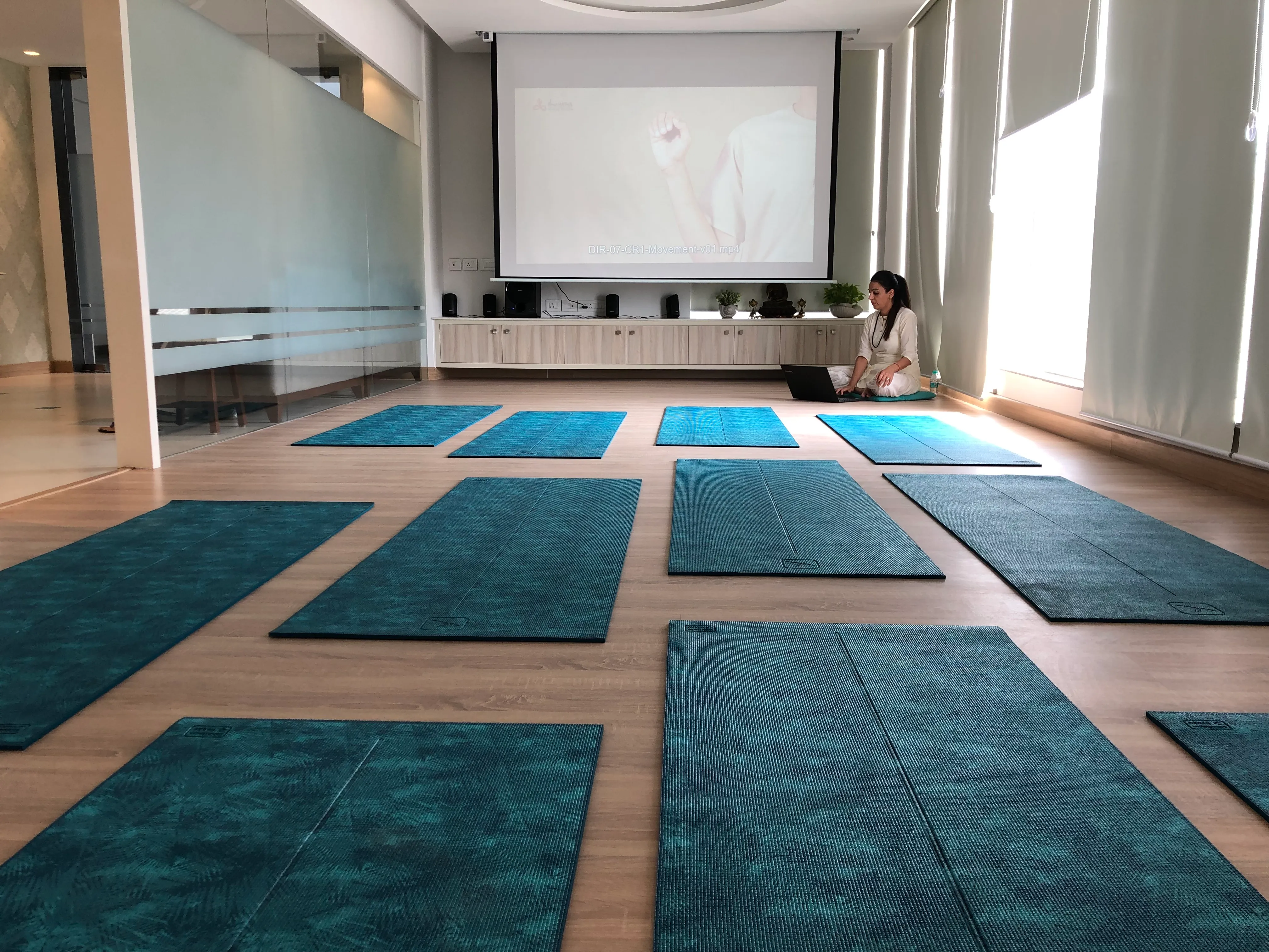 Bright group studio at Prana arranged with teal yoga mats